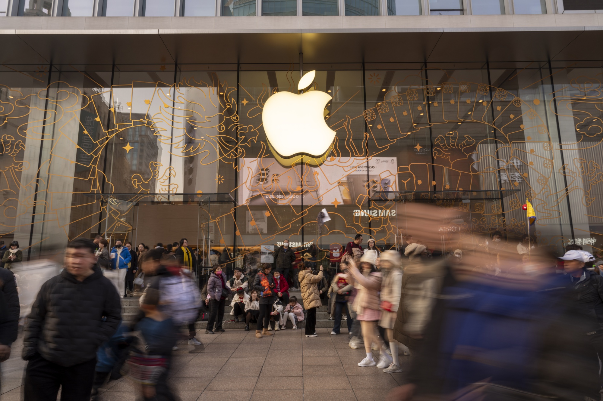 Shoppers pass an Apple Inc. store on East Nanjing Road in Shanghai, China.