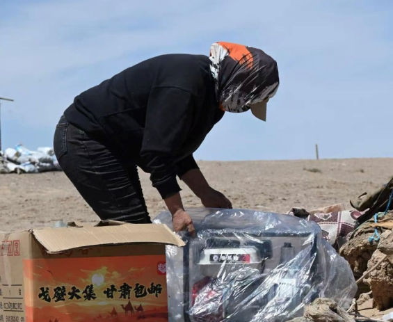 在河西走廊的牧区，当地牧民正拆开从拼多多上网购回来的发电机。（陈蕾 摄）
