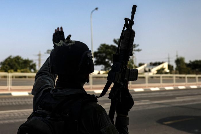 An Israeli soldier gestures to troops as they take a position near the southern city of Sderot on Sunday.