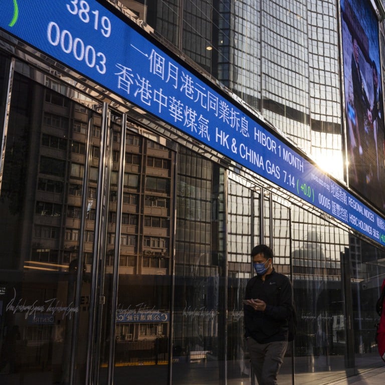 People walk past the Hong Kong Stock Exchange electronic screen outside the Exchange Square in Central, Hong Kong in March 2023. Photo: AP